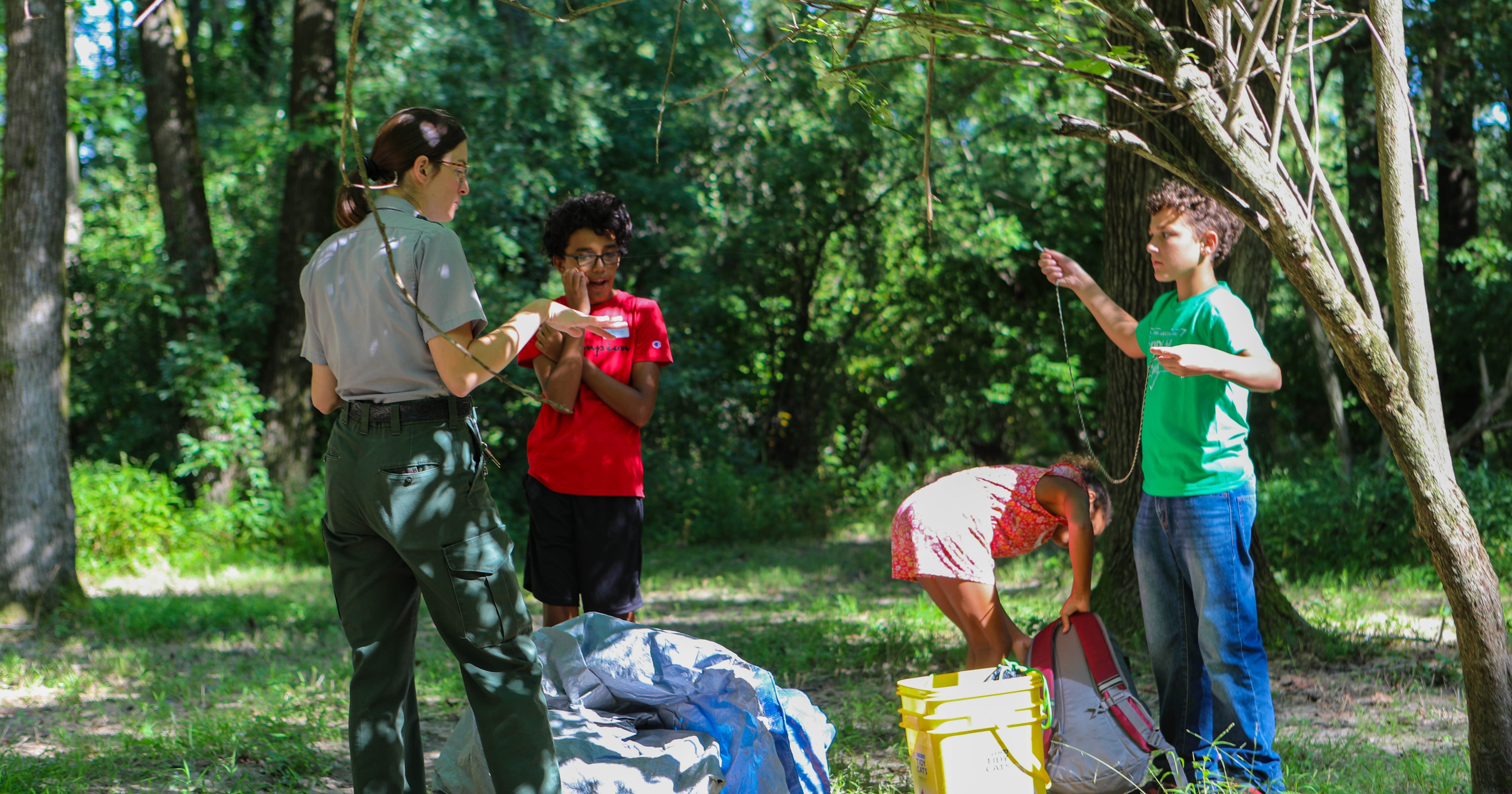 Campers receive shelter-building advice from a Park Ranger.